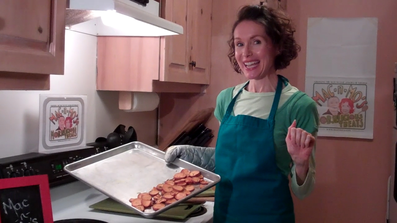 Health Coach, Mo the Morselist, in the kitchen holding a tray of baked sweet potato chips.