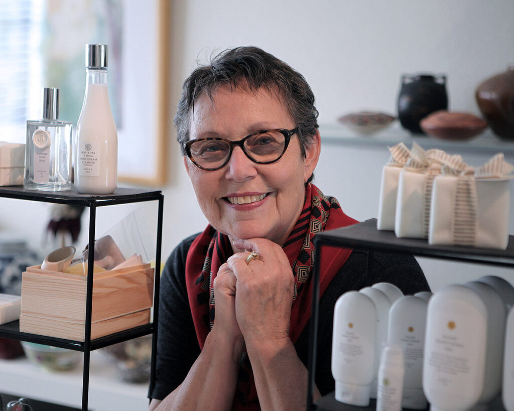 Caryl B of Caryl B. Skincare poses next to a display of her health and beauty products.