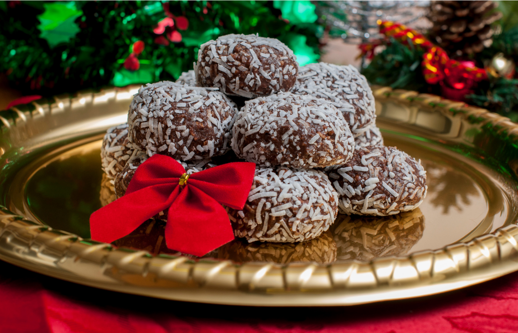 Minty cocoa balls piled on a gold plate with a red bow.